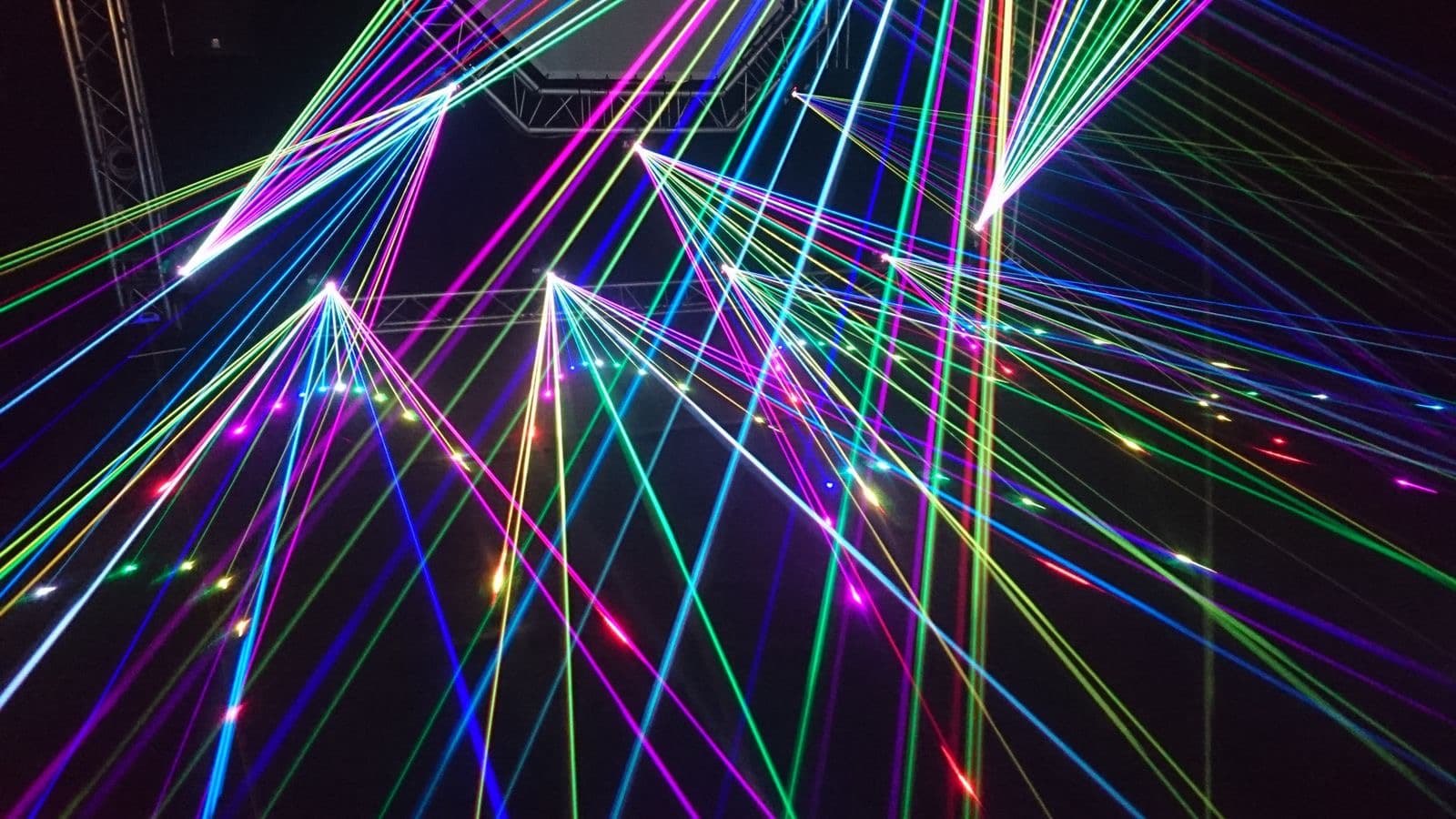 Multicolored laser beams crossing a dark room